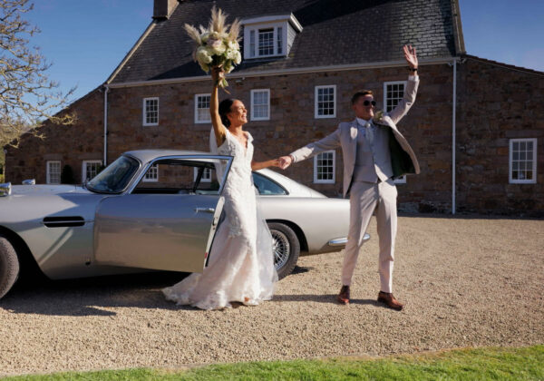 Couple outside their car on their wedding day at La Mare Wine Estate, Jersey