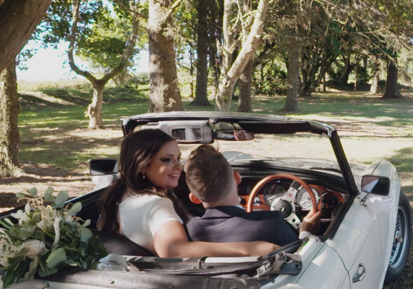 Bride and groom in convertible classic car in the vineyard at La Mare Wine Estate