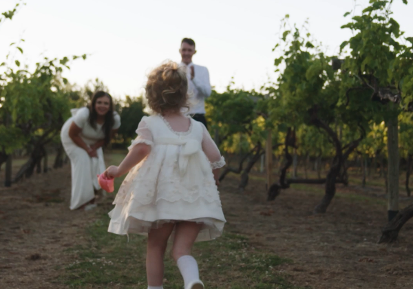 Bride and groom with their child playing in the vines at La Mare Wine Estate